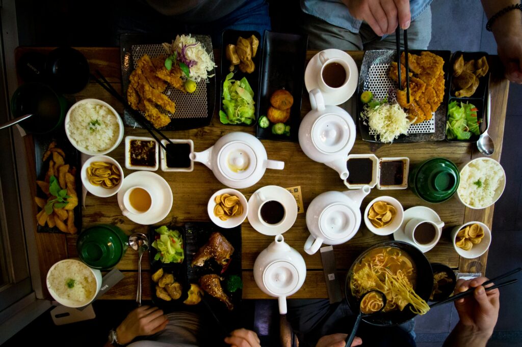 pexels-photo-1310777-1310777 A vibrant spread of traditional Taiwanese dishes with teapots and sides on a wooden table.