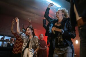 Energetic group of people enjoying a fun night out dancing and smiling at a lively club.
