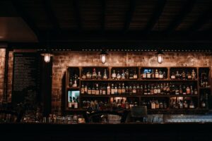 Warm and inviting bar interior showcasing a variety of liquors on wooden shelves.
